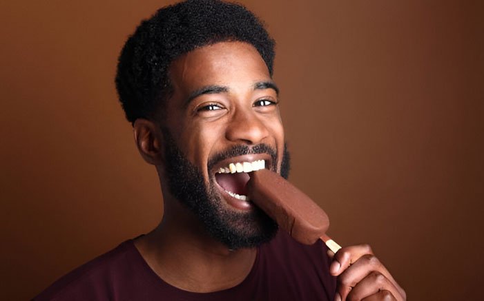Man happily biting into an ice cream bar